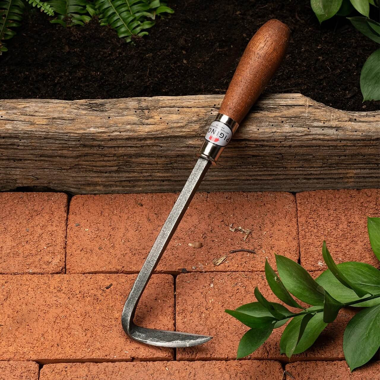 Desmalezador manual de acero con mango de madera para control de malezas en el jardín